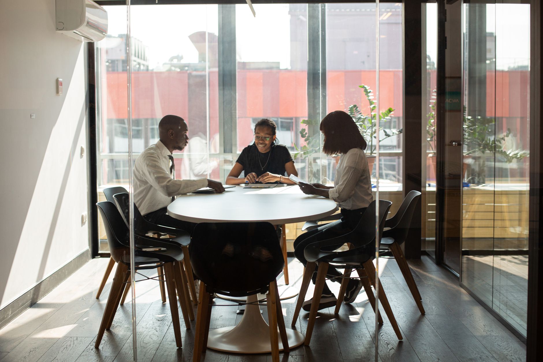 Corporate negotiations across standard glass boardroom tables